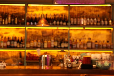 Photo of Blurred view of bottles on shelves in bar