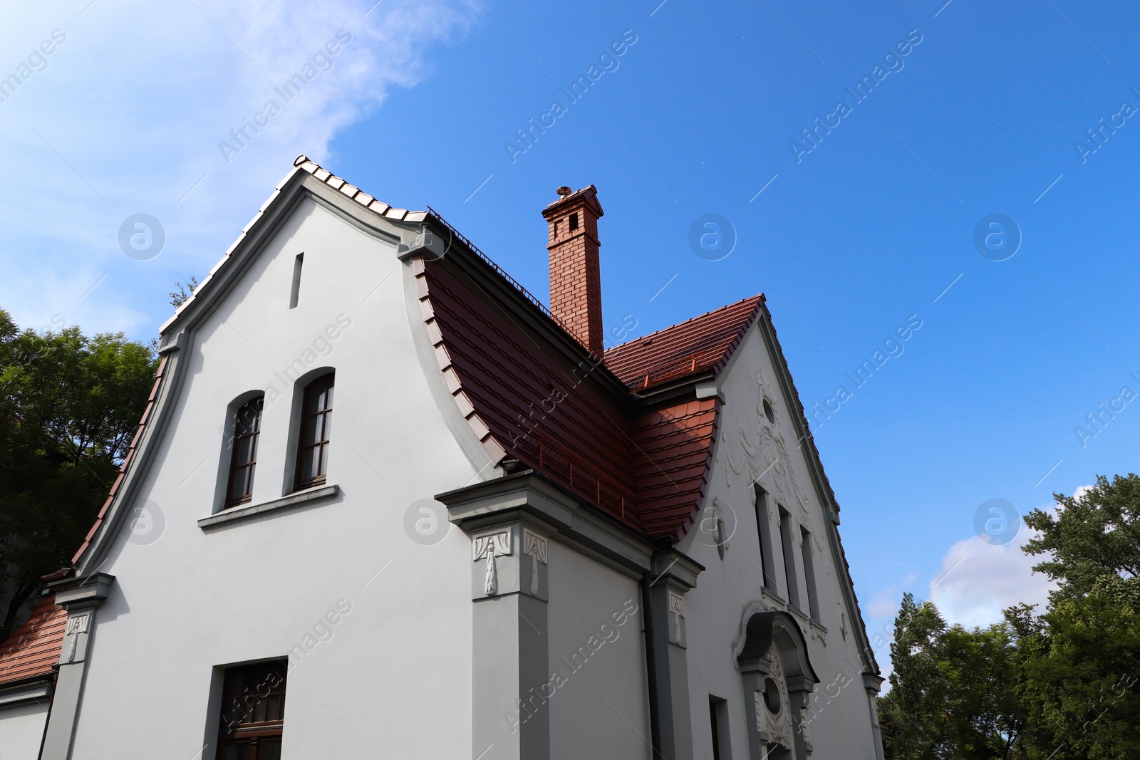 Photo of Beautiful house with brown roof against blue sky