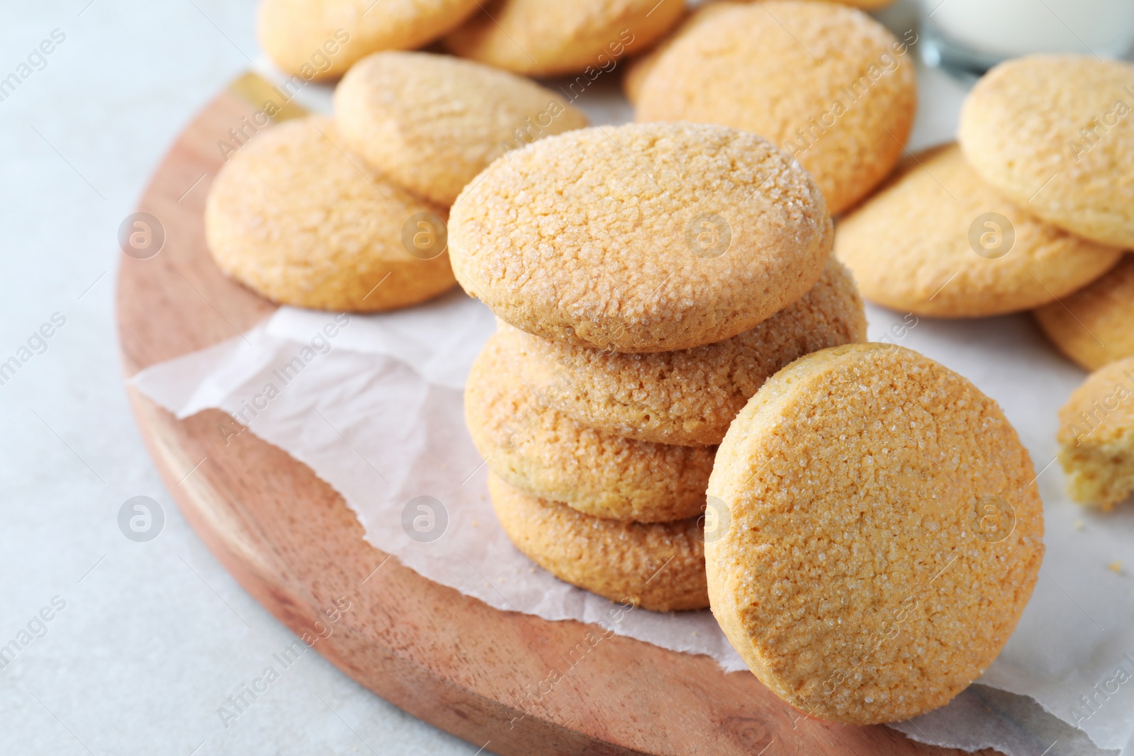 Photo of Many tasty sugar cookies on wooden board, closeup