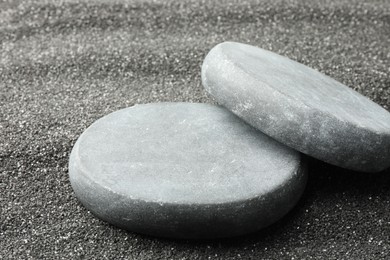 Photo of Presentation of product. Stone podiums on black sand, closeup