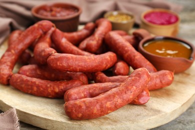 Photo of Delicious sausages, ketchup, mustard and horseradish on wooden table, closeup