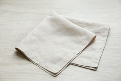 Photo of Light folded napkin on white wooden table