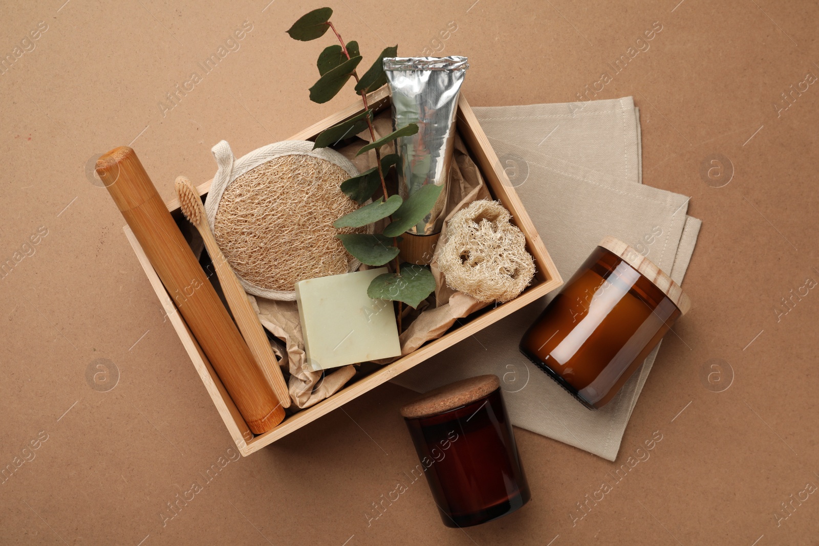 Photo of Wooden box with eco friendly products on craft paper, flat lay