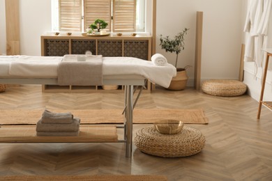 Photo of Stylish massage room interior with spa table in salon