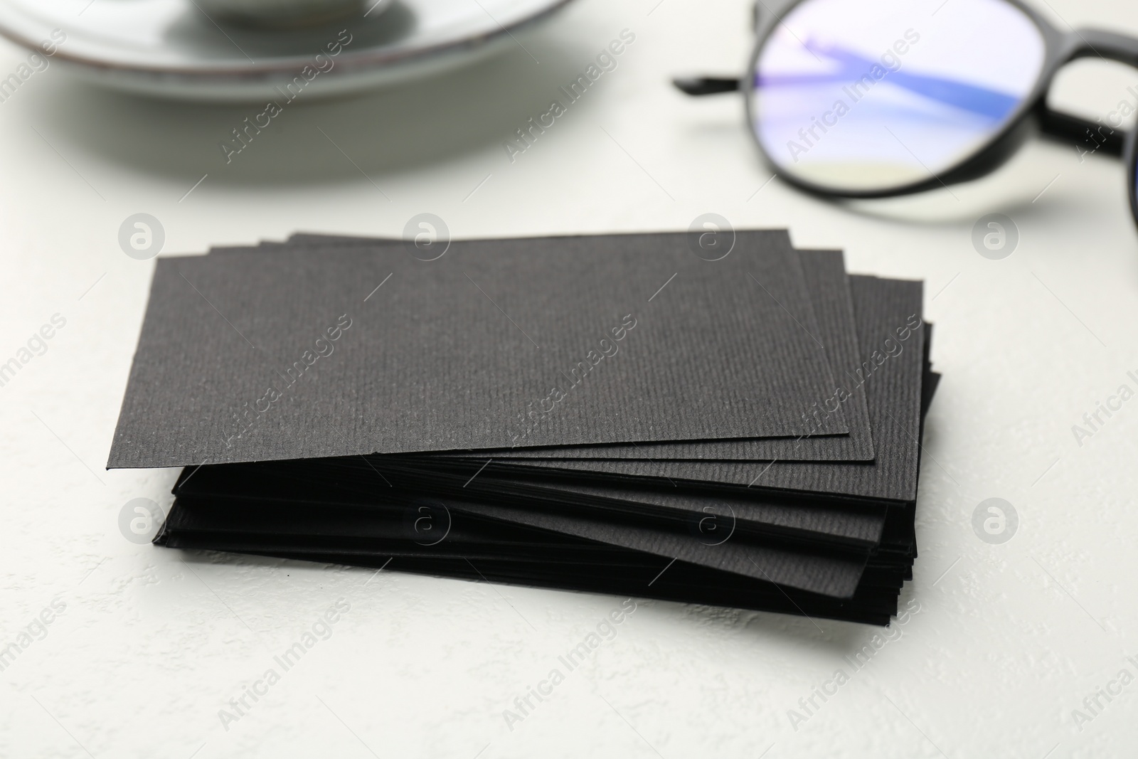 Photo of Blank black business cards on white table, closeup. Mockup for design