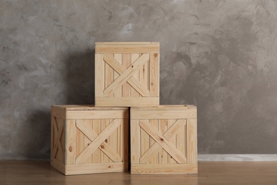 Photo of Wooden crates on floor against color background, space for text