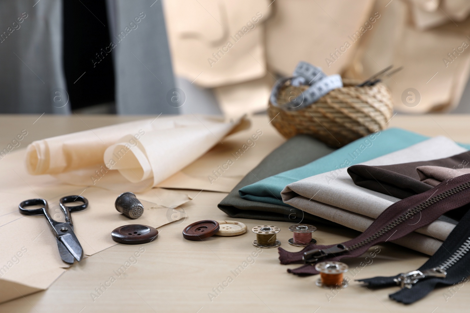 Photo of Set of sewing supplies and accessories with fabric on wooden table indoors