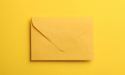 Photo of Paper envelope on yellow background, top view