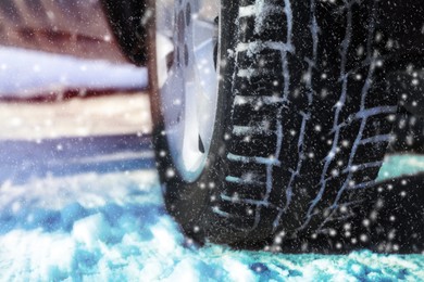 Car with winter tires on snowy road, closeup view