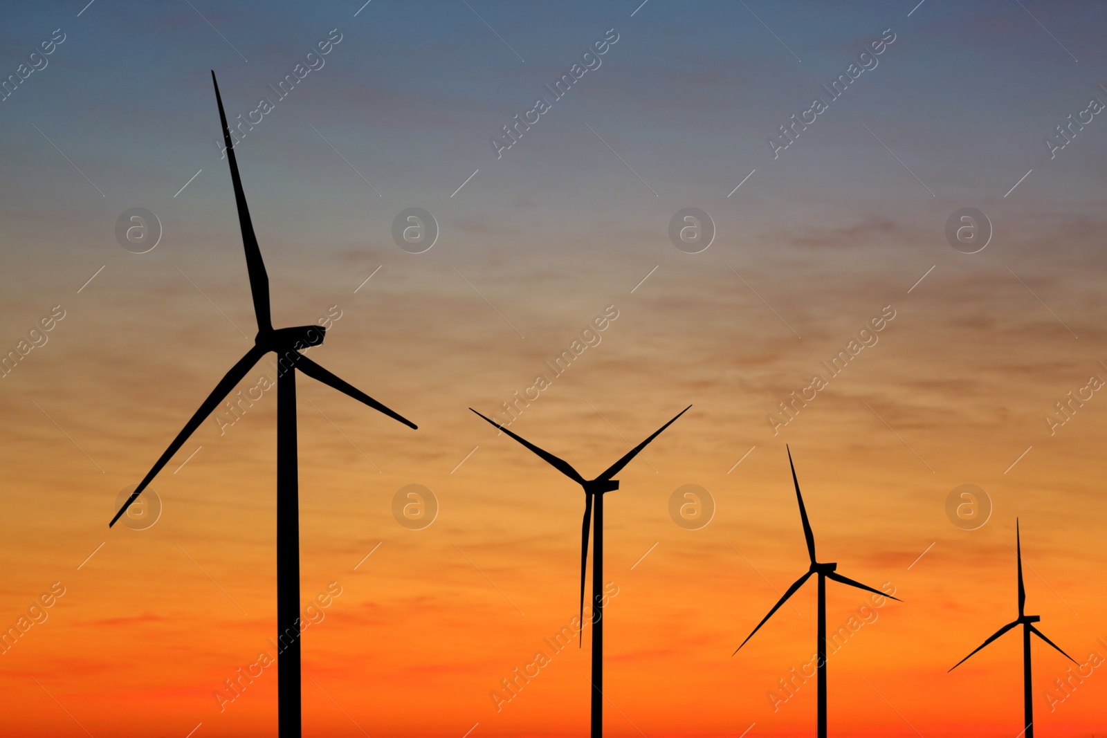 Image of Silhouettes of wind turbines at sunset. Alternative energy source