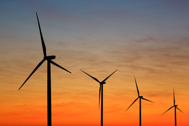 Image of Silhouettes of wind turbines at sunset. Alternative energy source