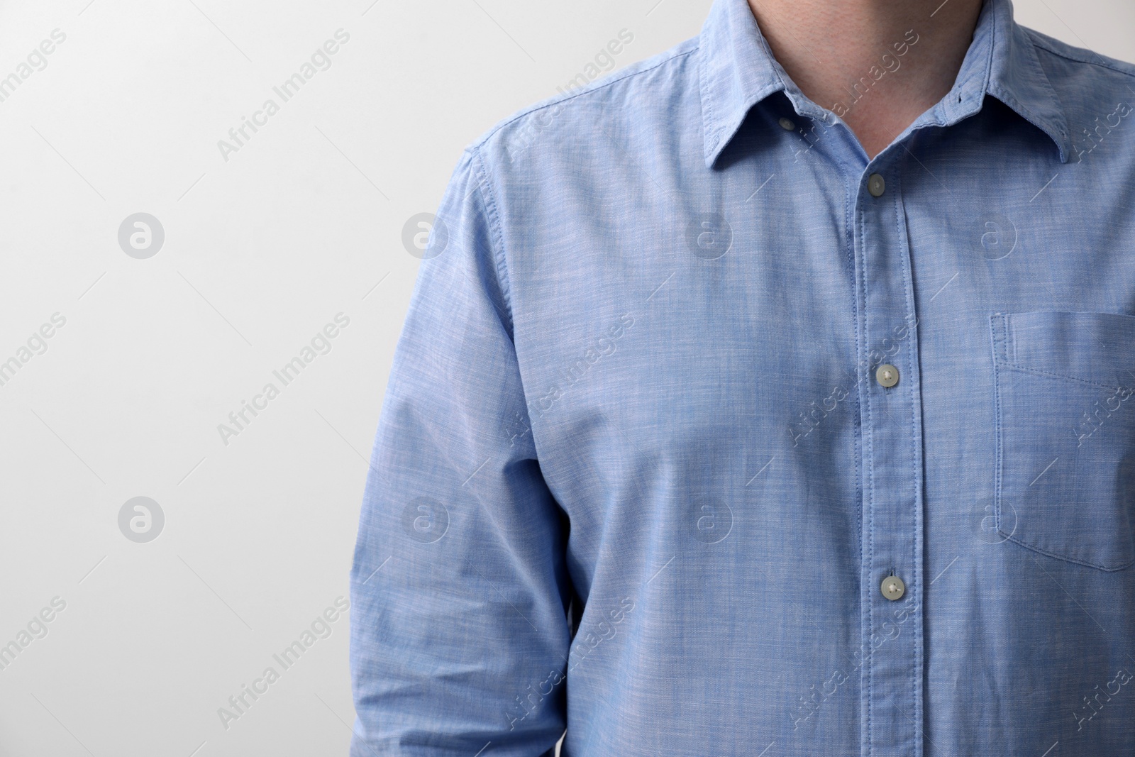 Photo of Man wearing light blue shirt on white background, closeup