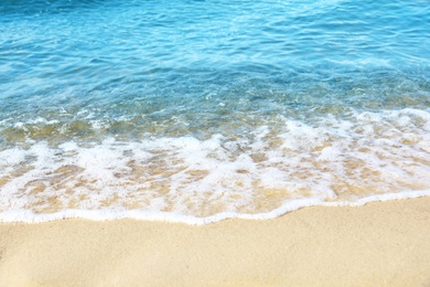 Photo of View of sea water and beach sand on sunny day