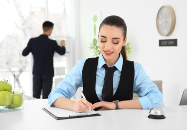 Busy female receptionist at workplace in hotel