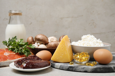 Photo of Fresh products rich in vitamin D on light grey table