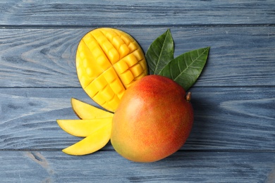 Flat lay composition with mango on wooden background