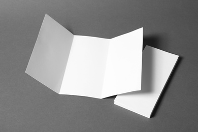 Photo of Empty flyers on grey background. Mockup for design