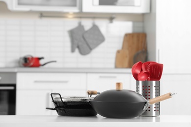 Set of clean cookware and utensils on table in kitchen. Space for text