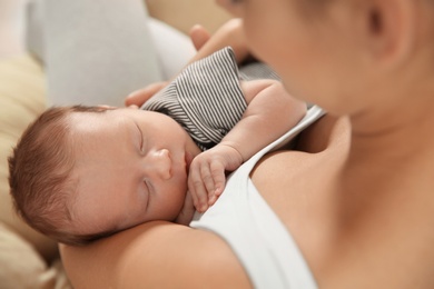 Photo of Young woman holding her newborn baby, closeup
