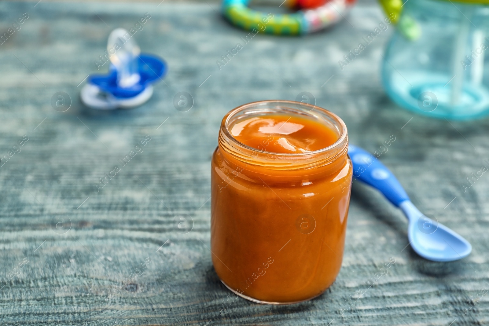 Photo of Jar with healthy baby food on wooden table