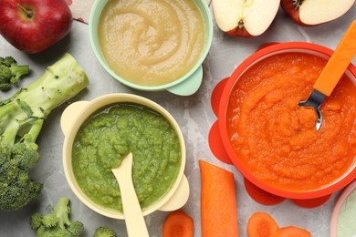 Photo of Healthy baby food. Different tasty puree in bowls on light grey marble table, flat lay