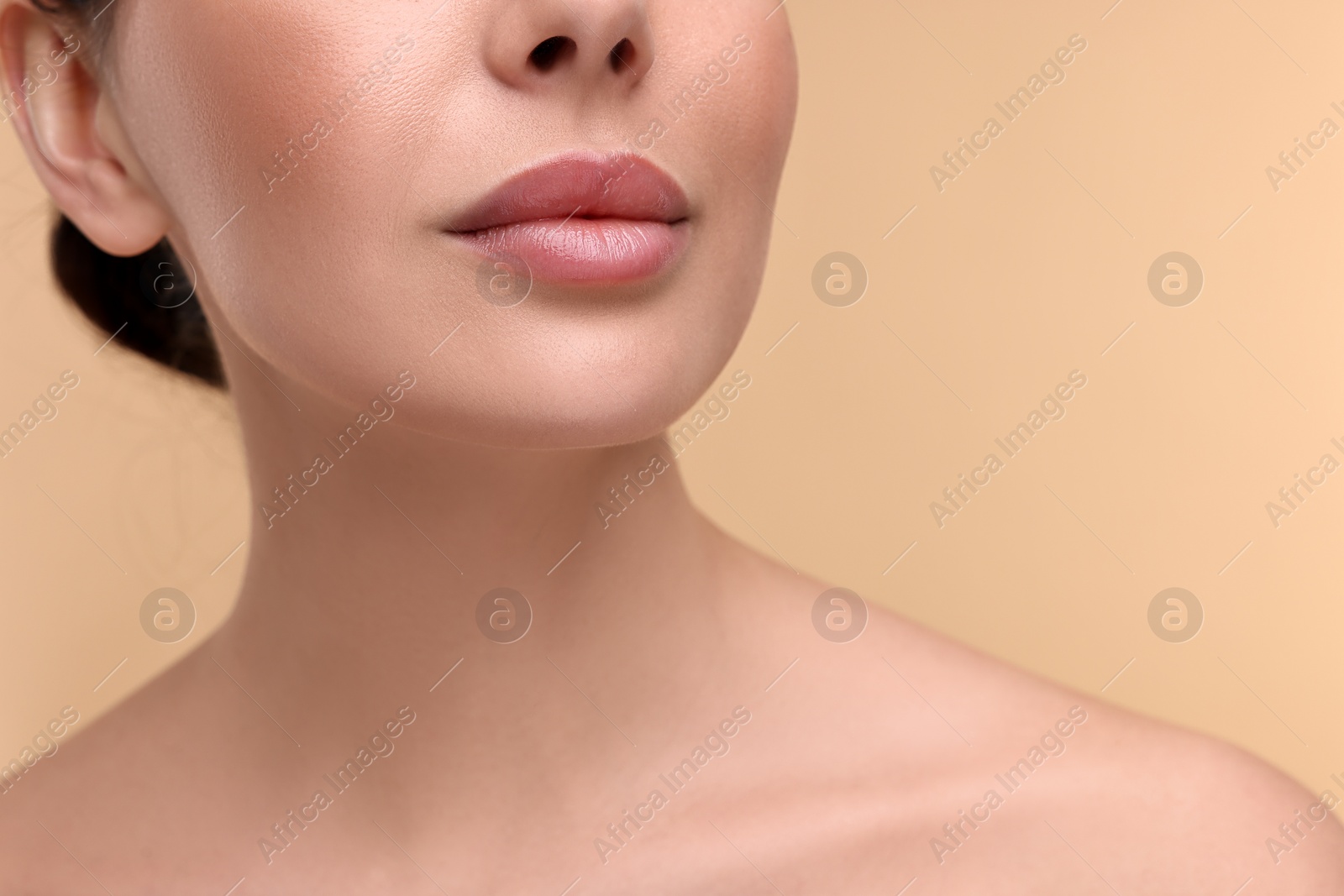 Photo of Woman with beautiful lips on beige background, closeup. Space for text