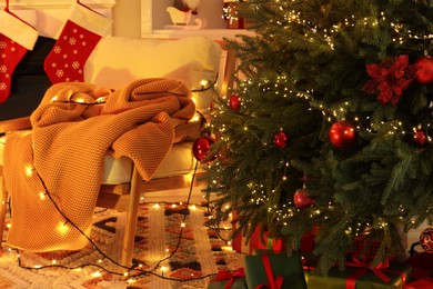 Photo of Cozy room with armchair and Christmas decor. Interior design