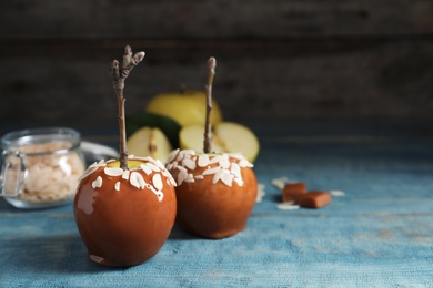 Photo of Delicious caramel apples on wooden background