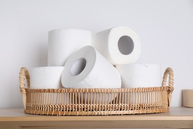 Photo of Toilet paper rolls on wooden table near white wall