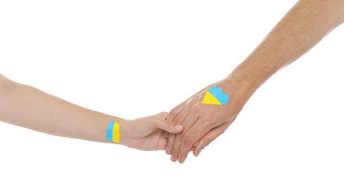 Photo of Man and woman with painted Ukrainian flags on their hands against white background, closeup