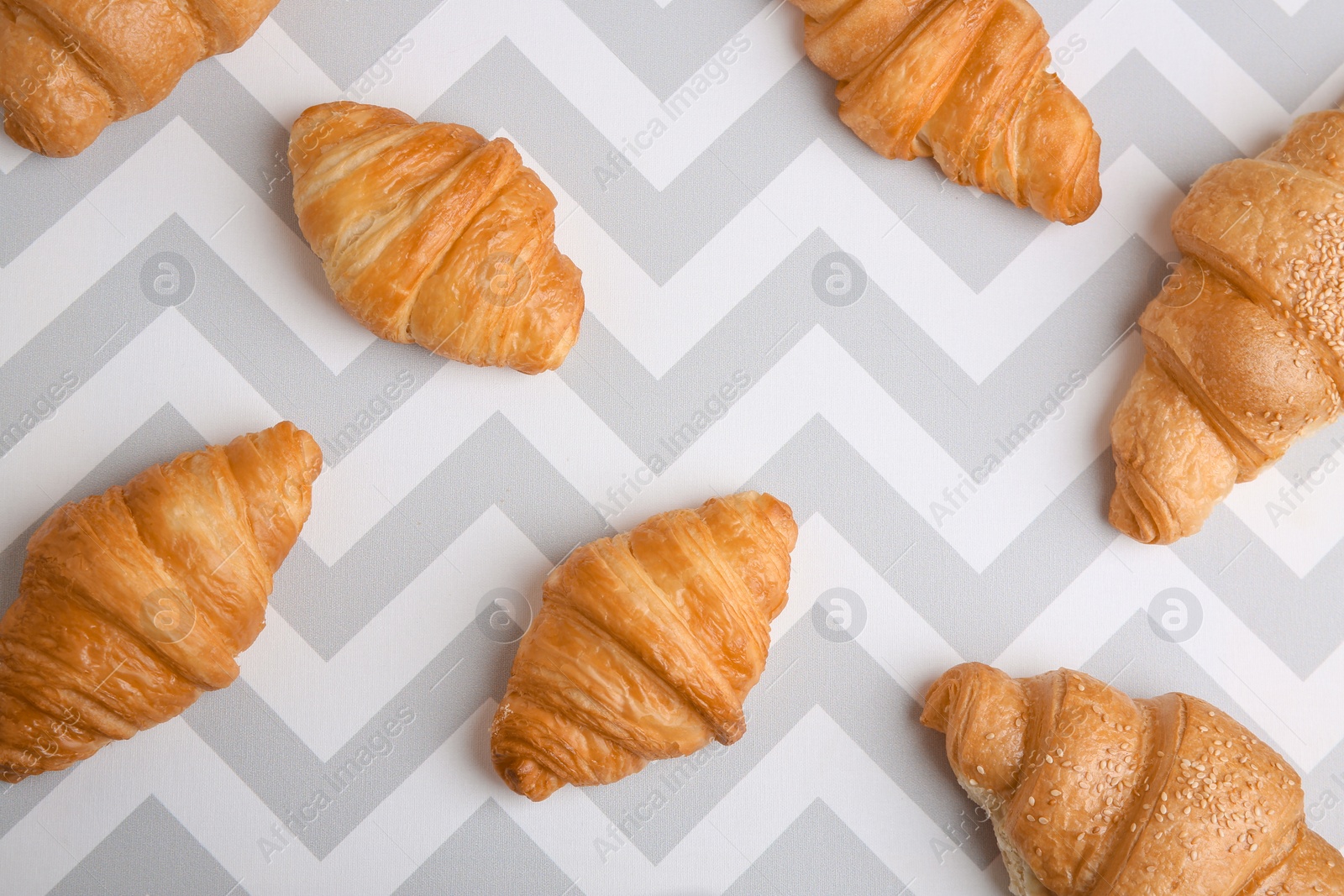 Photo of Flat lay composition with tasty croissants on patterned background