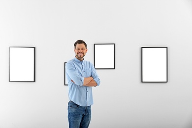 Man near wall with exposition in modern art gallery
