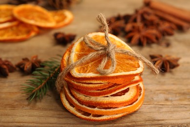 Dry orange slices and fir branch on wooden table, closeup