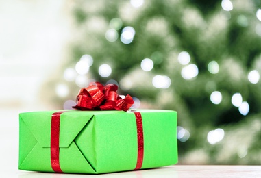 Photo of Christmas gift on table against blurred background