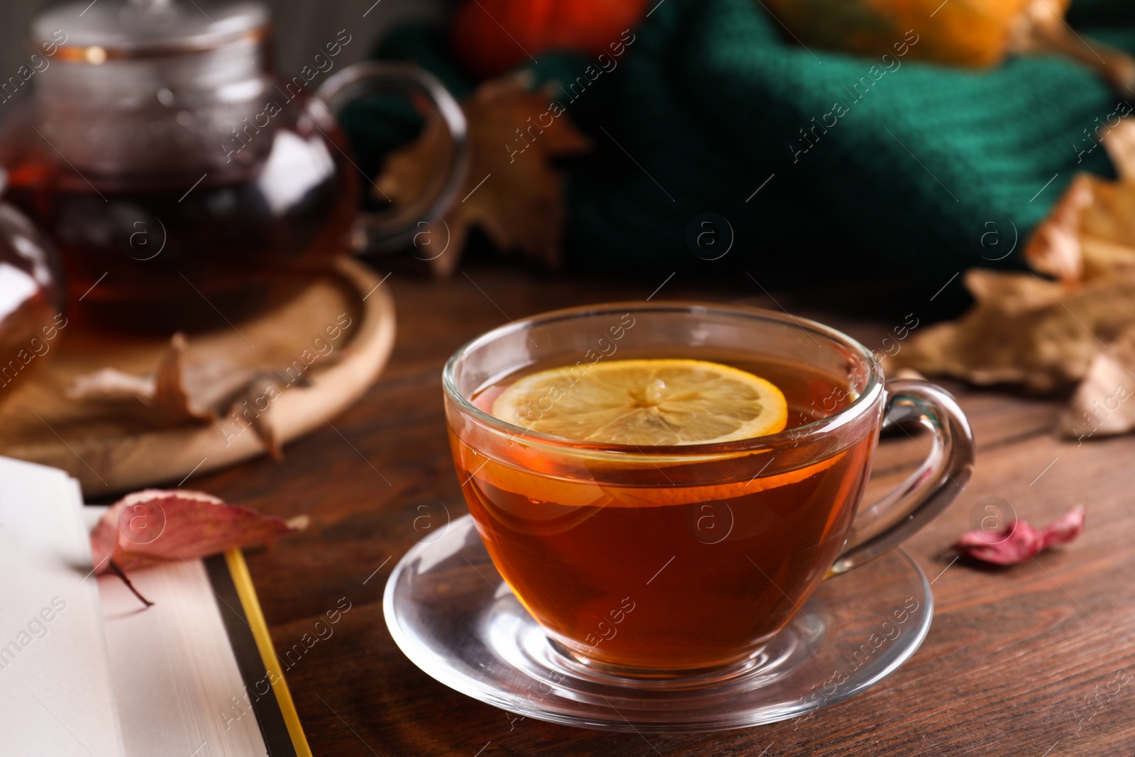 Photo of Cup of hot drink and book on wooden table. Cozy autumn atmosphere