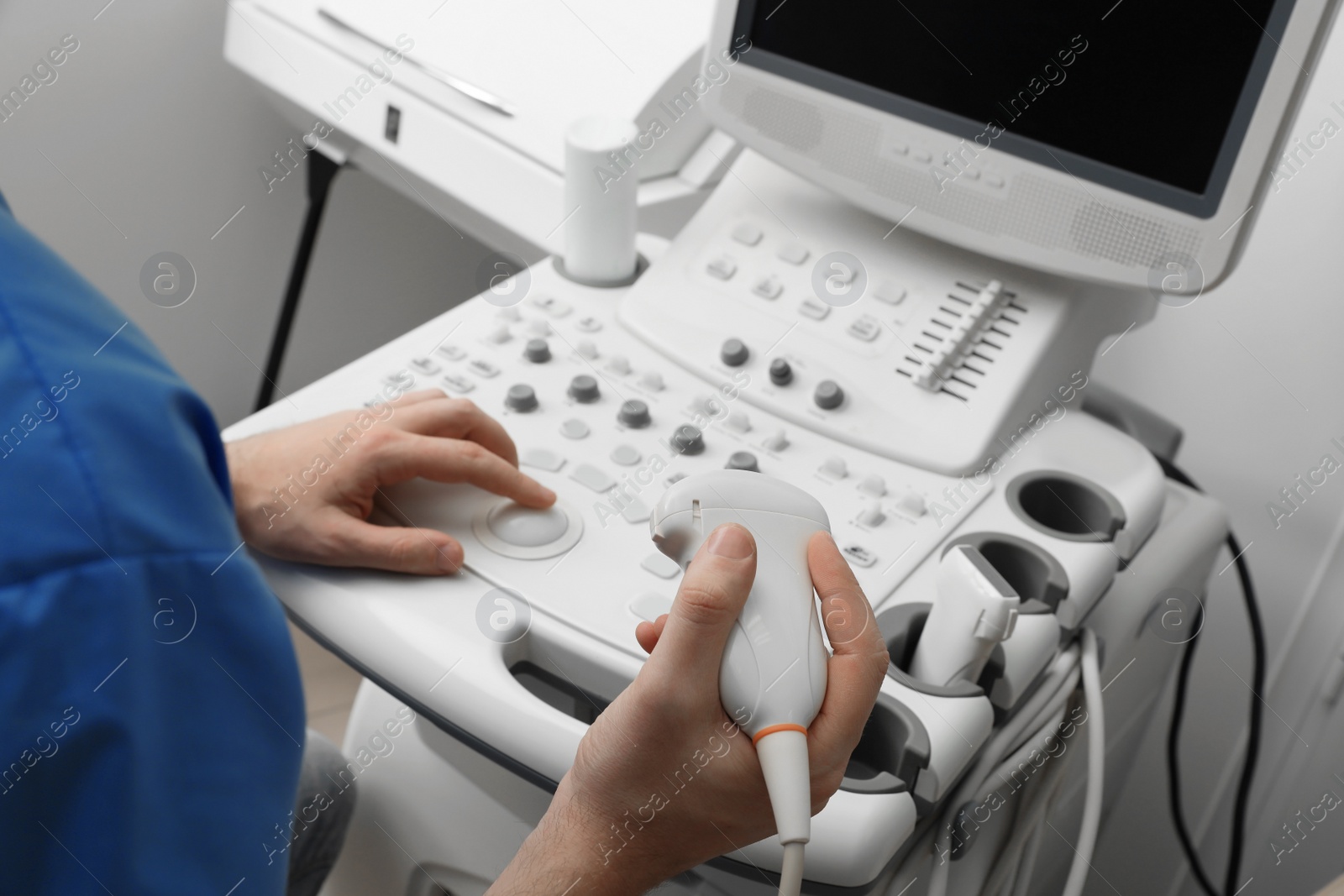 Photo of Sonographer operating modern ultrasound machine in clinic, closeup