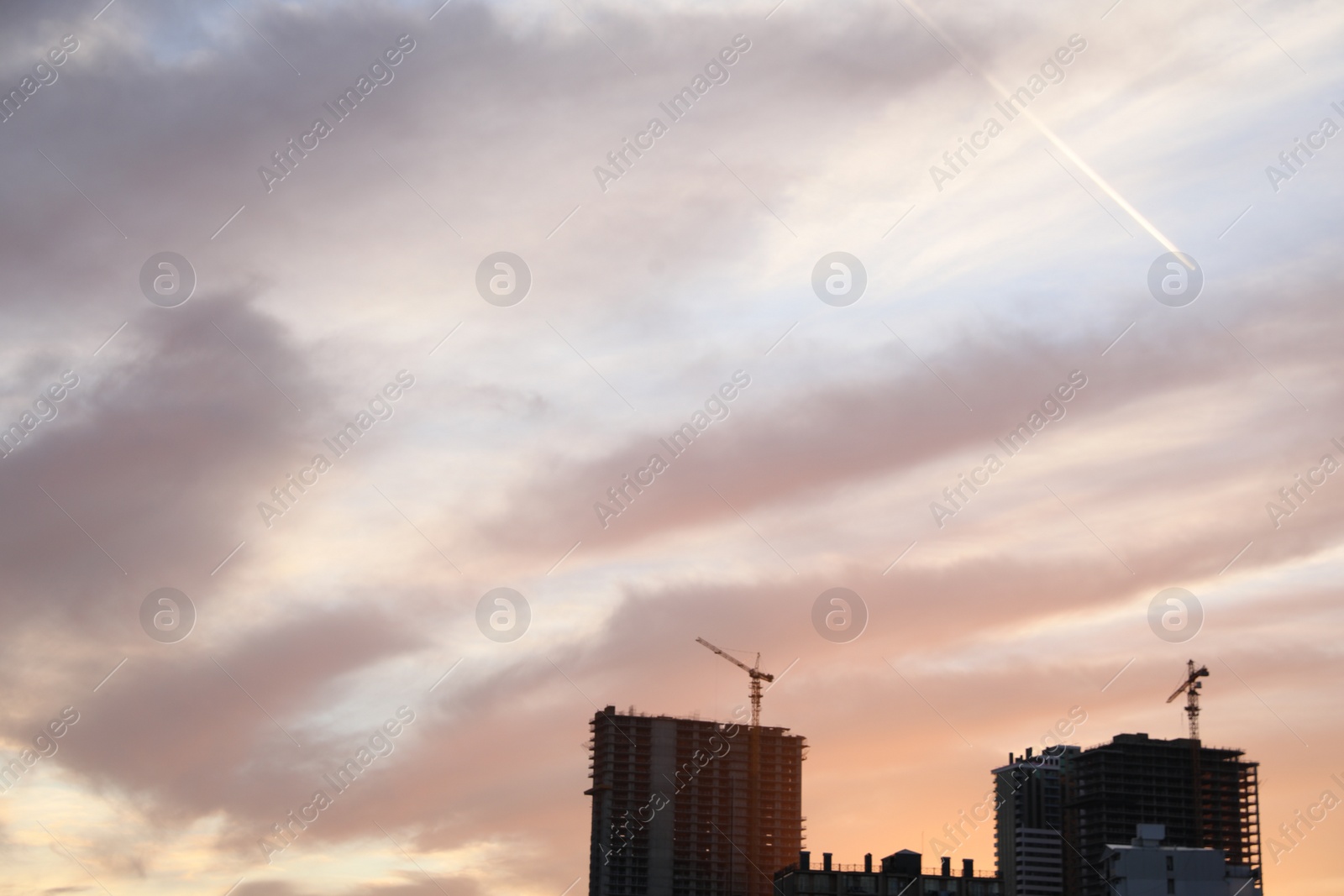 Photo of Tower cranes near unfinished buildings in city