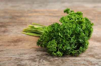 Photo of Bunch of fresh green parsley on wooden table