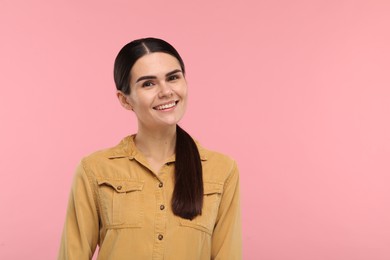 Young woman with clean teeth smiling on pink background, space for text