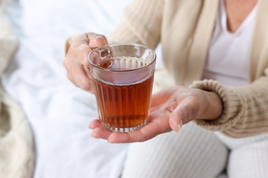 Photo of Elderly woman with cup of hot tea indoors, closeup. Home care service