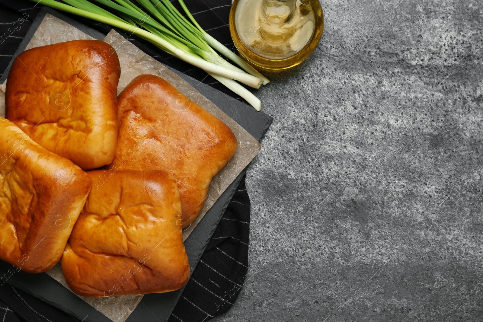 Photo of Flat lay composition with delicious baked patties on grey table. Space for text