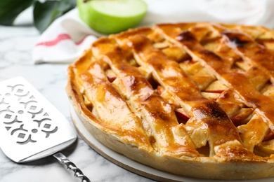 Photo of Fresh traditional apple pie on white marble table, closeup
