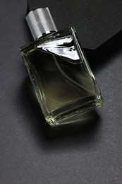 Photo of Stylish presentation of luxury men`s perfume in bottle on black background