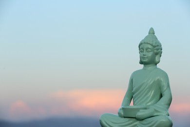 Decorative Buddha statue against sky. Space for text