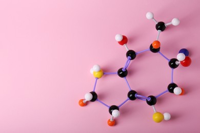Structure of molecule on pink background, top view and space for text. Chemical model