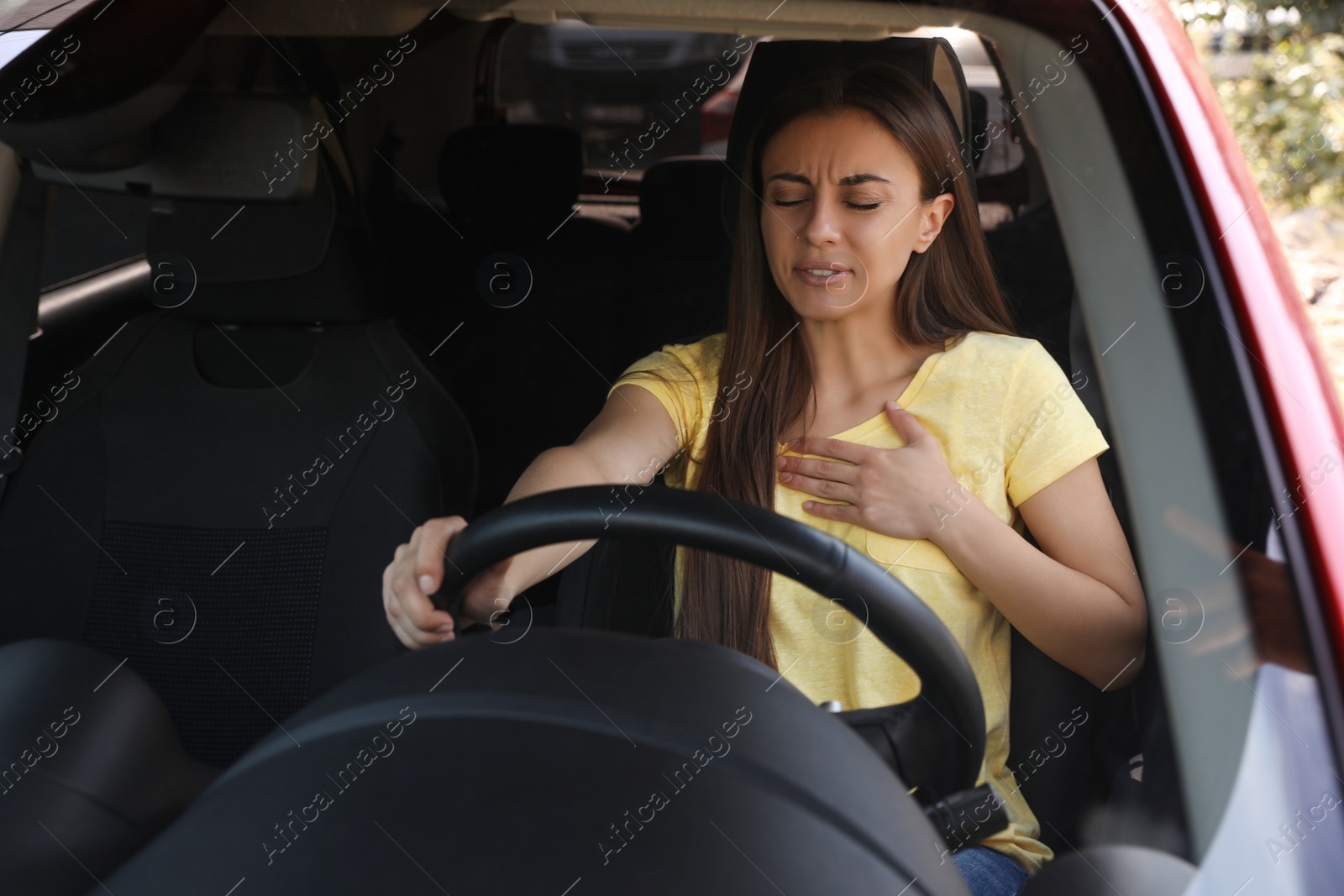 Photo of Young woman suffering from heart attack in car