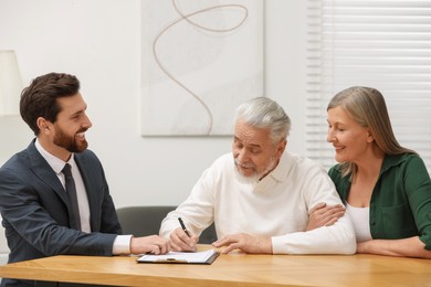 Notary consulting senior couple about Last Will and Testament in office
