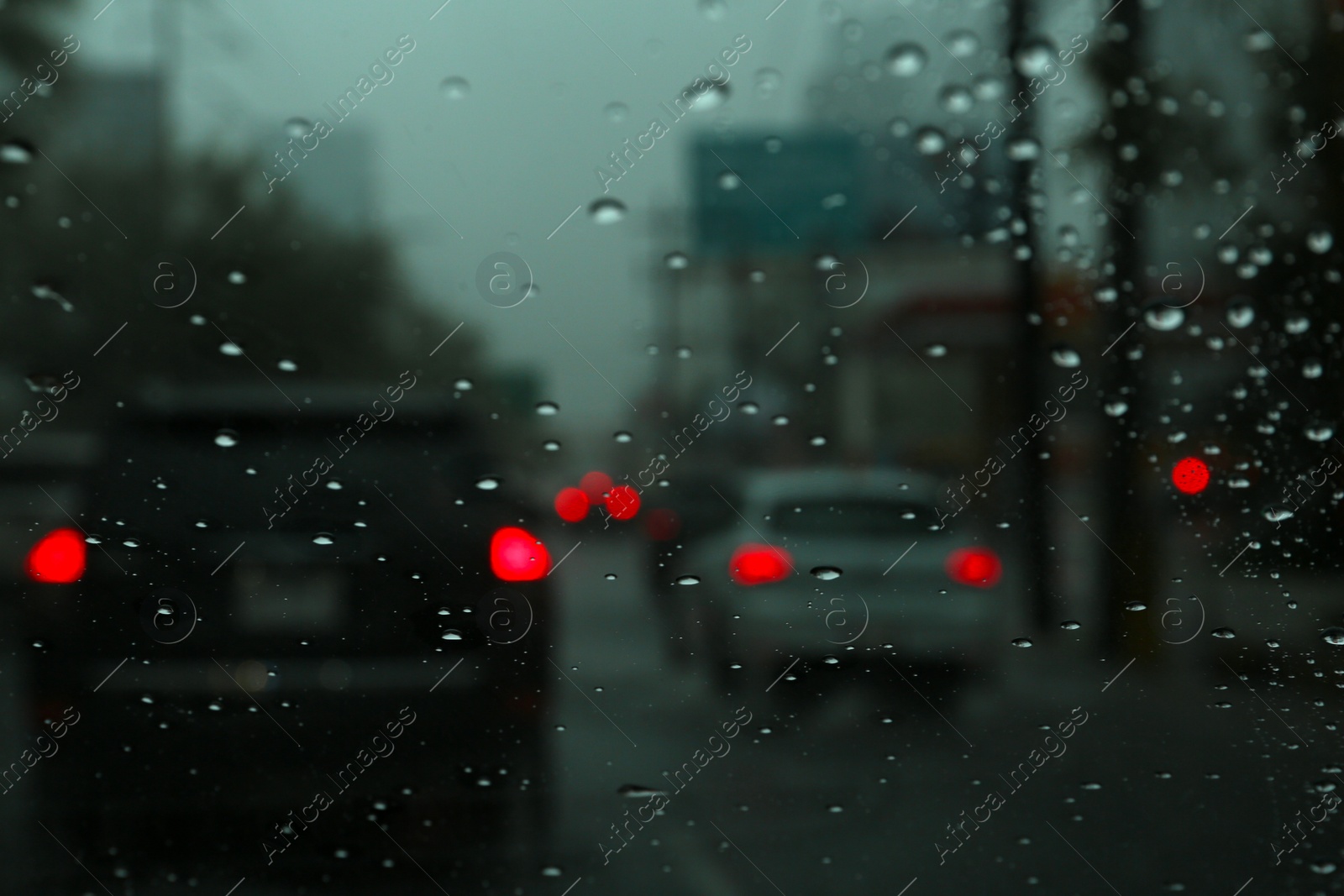 Photo of Road on rainy day, view through car window with water drops