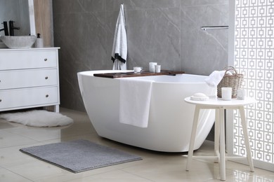 Modern white tub and chest of drawers with sink in bathroom. Interior design