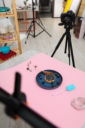 Photo of Professional equipment and composition with delicious dessert on pink background in studio, above view. Food photography